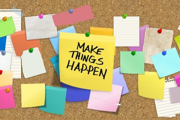 Bulletin board with sticky notes, including one that reads, "Make Things Happen".