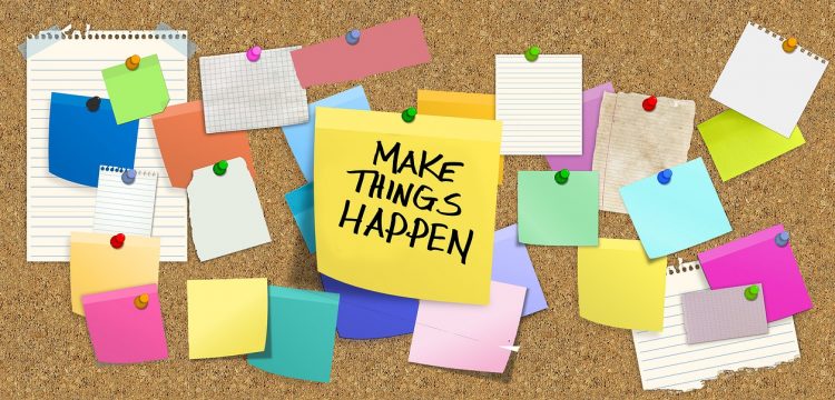 Bulletin board with sticky notes, including one that reads, "Make Things Happen".