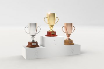 Three trophies on a podium.