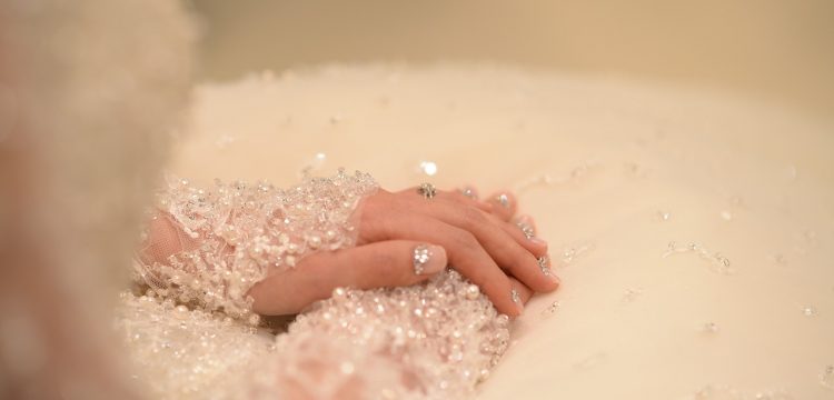 A bride's hands resting on her lap.