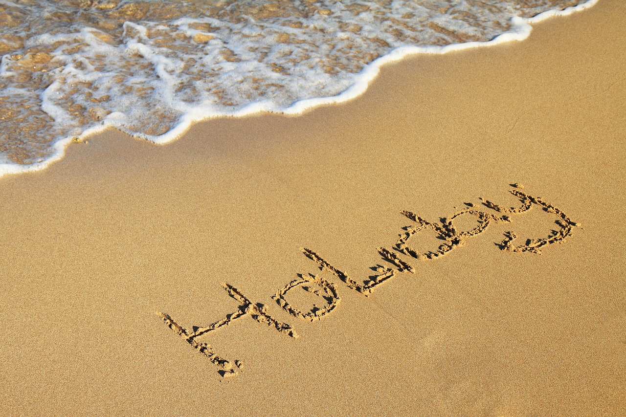 The word "holiday" written in the sand.