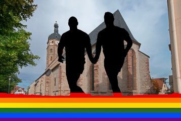 A gay couple with a rainbow flag.