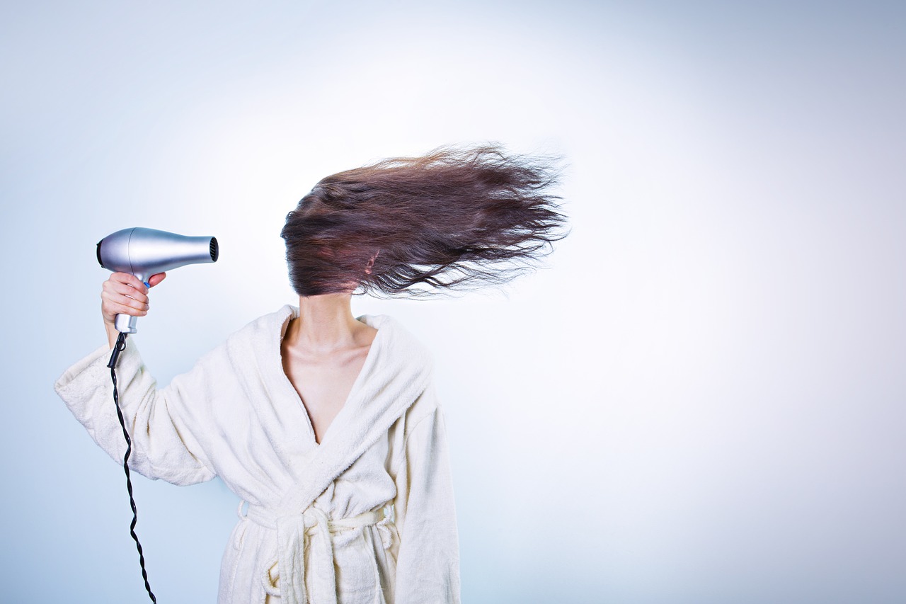 Woman blow drying her hair.