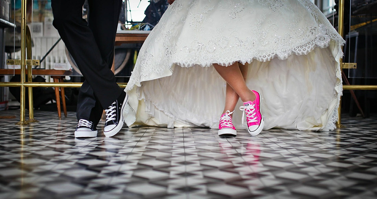 Bride and groom wearing sneakers with their wedding attire.