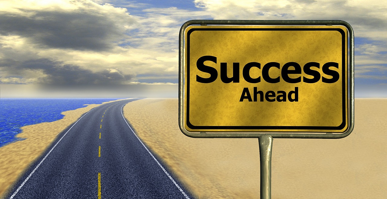 A road with a sign that reads, "Success Ahead".