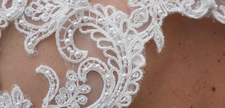 Close up of bridal gown material on a bride's shoulder.