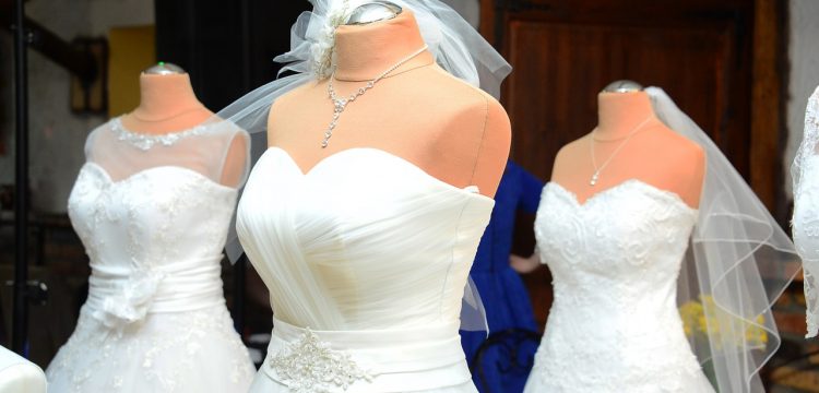 Three wedding dresses on mannequins.