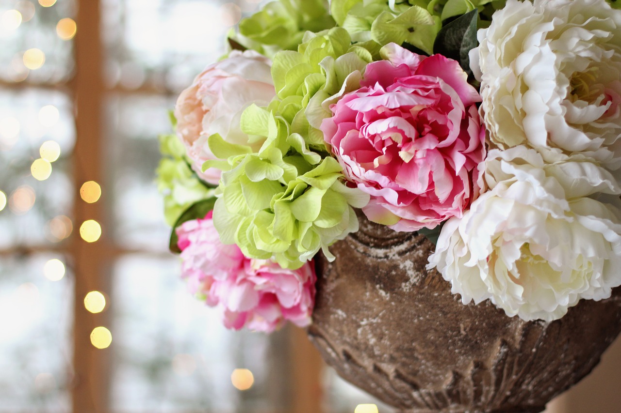 Green, pink, and white wedding flowers in a vase.