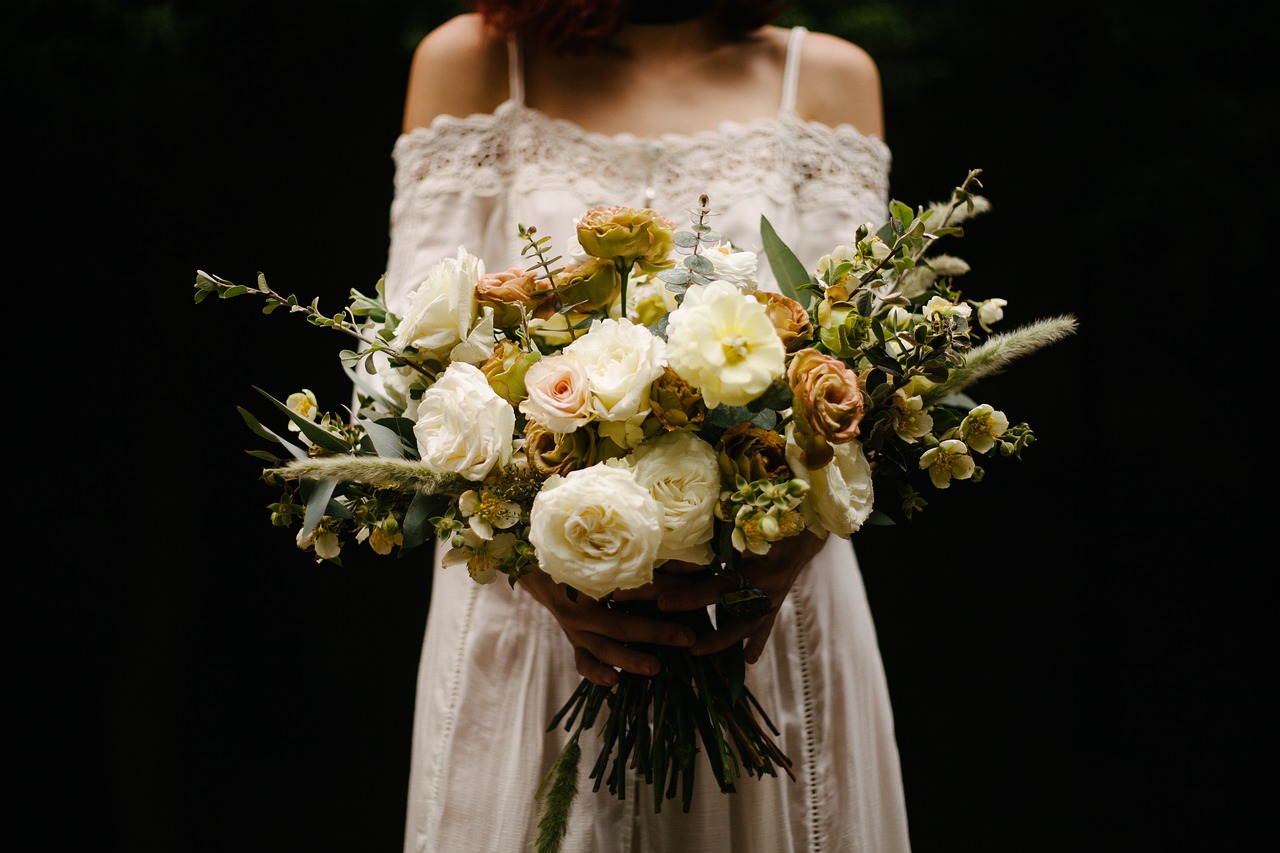 Boho-type bride holding a bouquet in front of her.