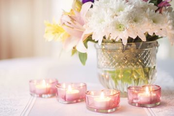 Floral centerpiece with candles surrounding it.