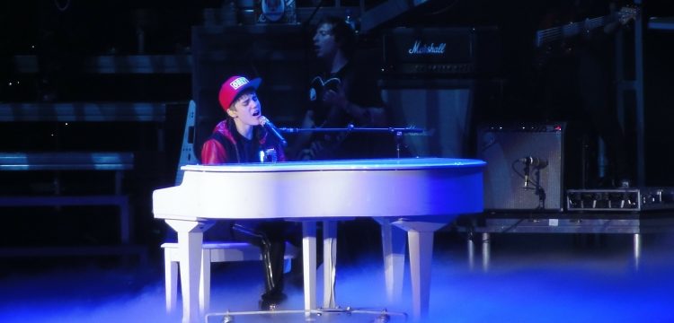 Justin Bieber, sitting at a piano.