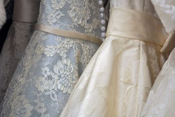 A row of hanging wedding gowns.