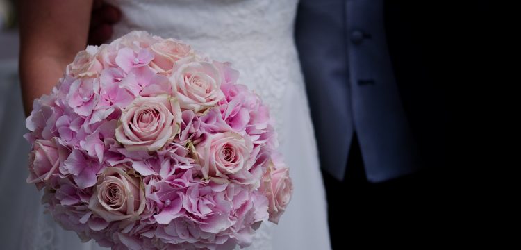 Bride holding a bouquet of roses.