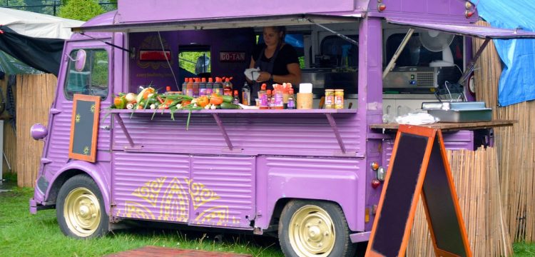 A purple food truck, serving drinks and food.