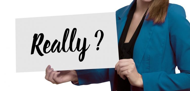 A businesswoman holding a large board with the word "Really?" on it.