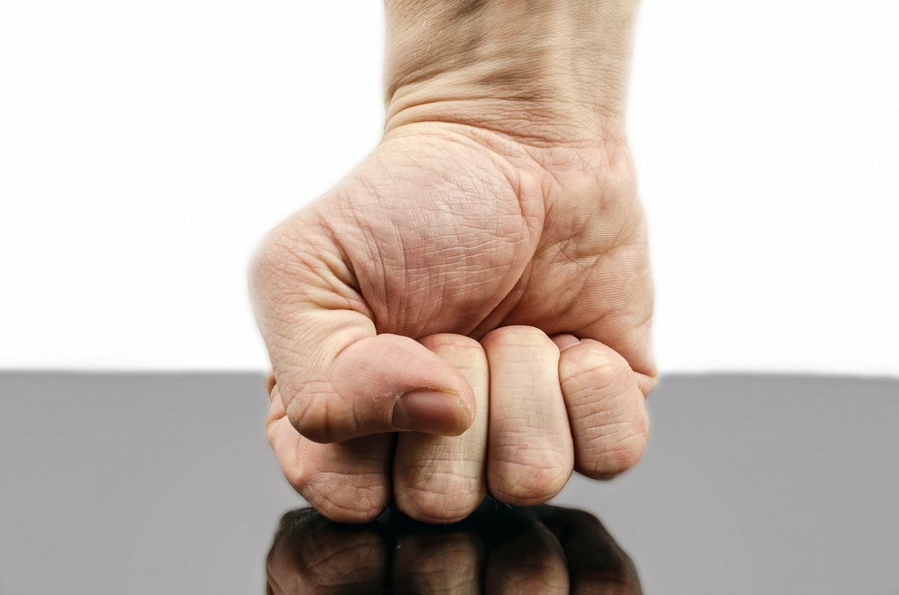 A man's fist hitting a table.