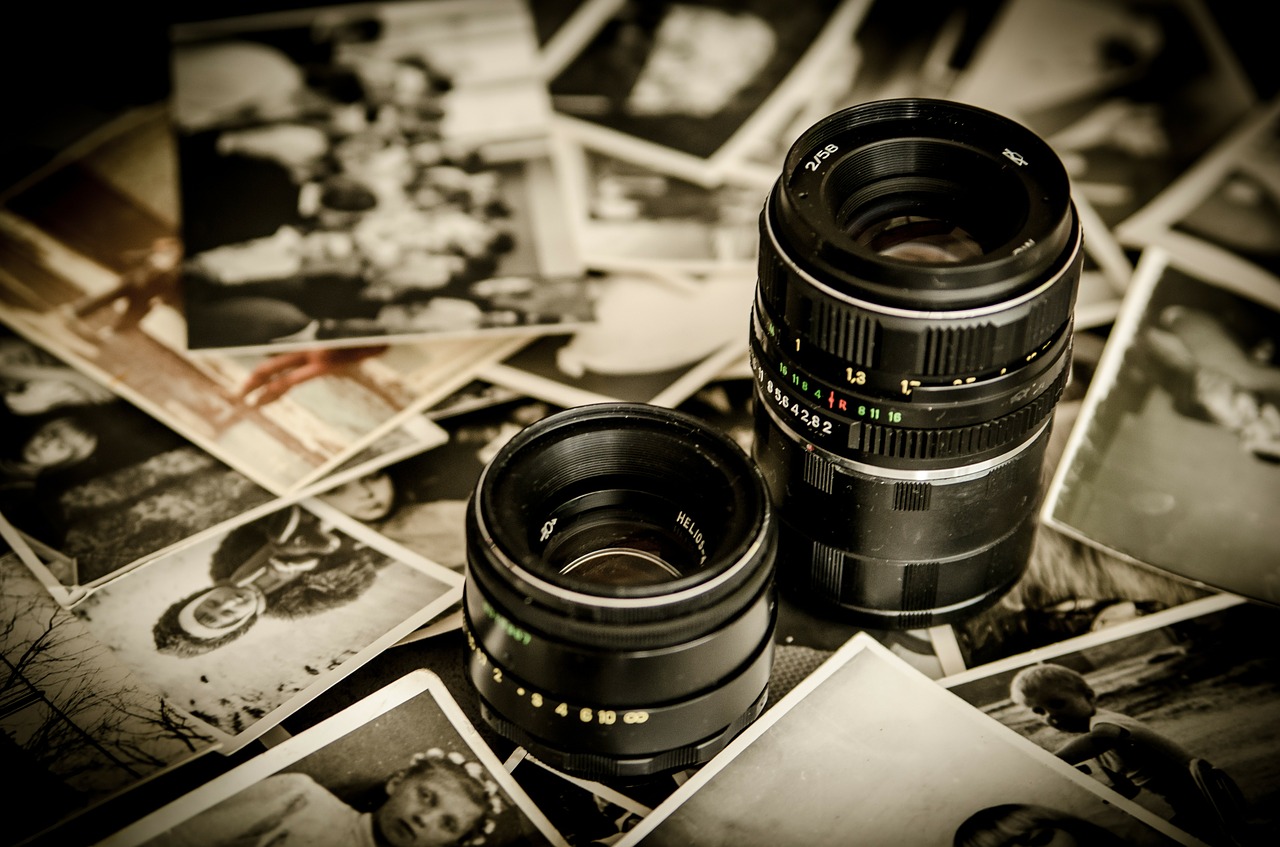 Two camera lenses surrounded by photographs.