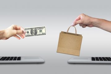 Graphic of one hand with a dollar bill and one hand with a shopping bag, reaching toward one another.