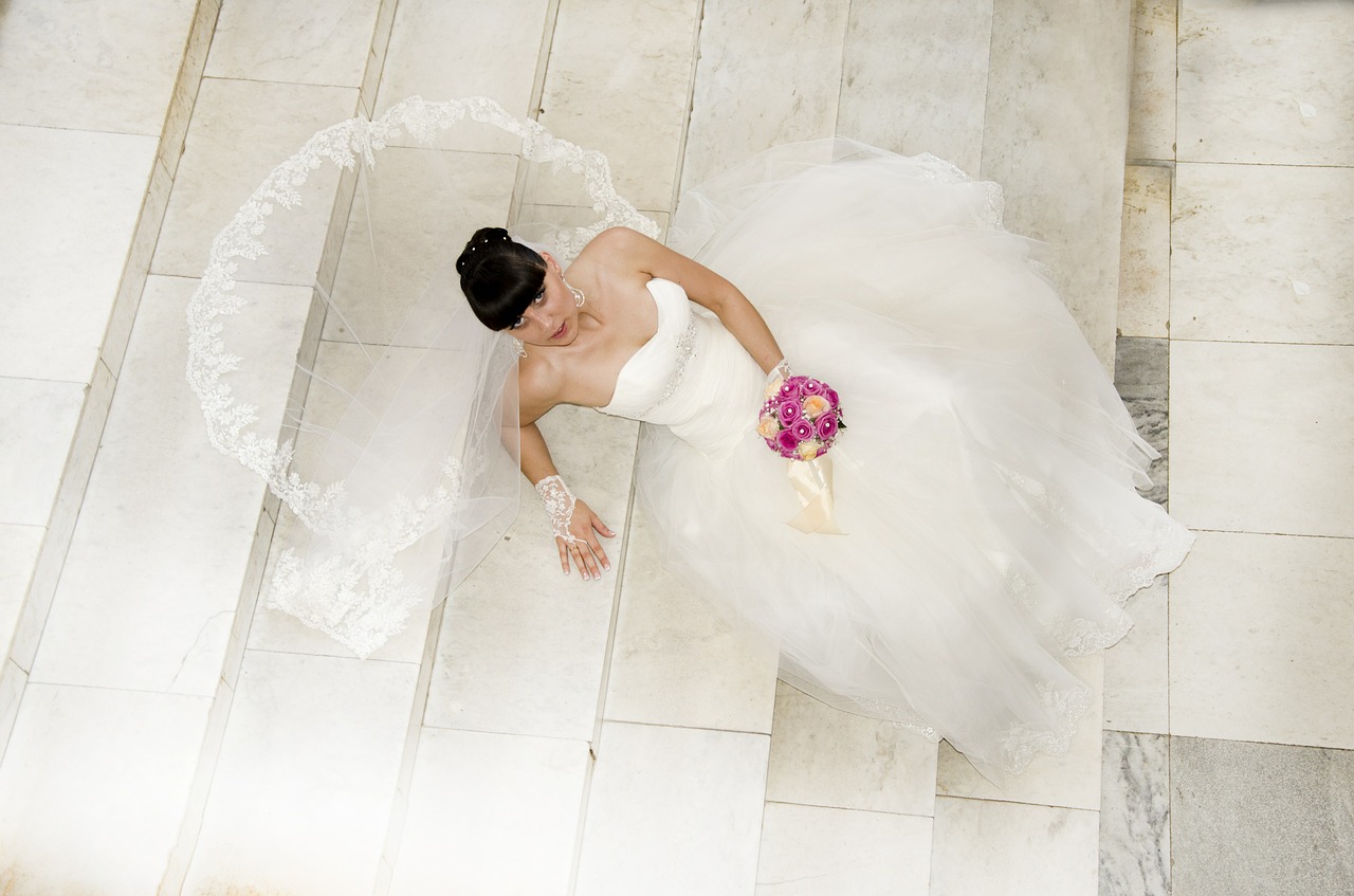 Model with wedding dress lying on white steps.