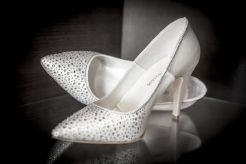 A pair of white sparkly bridal pumps.