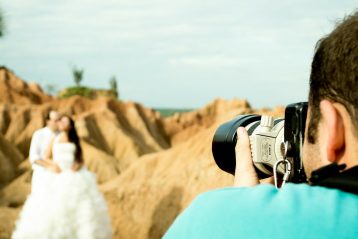 Photographer taking a picture of a married couple.
