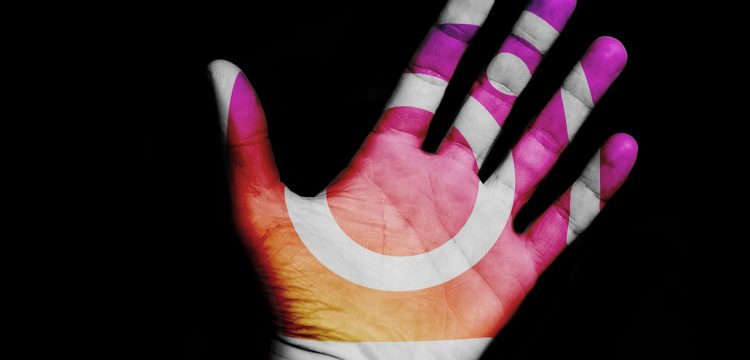 The Instagram symbol on an outstretched hand.
