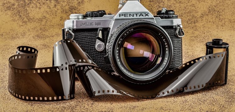 A Pentax camera with film coming out of it.