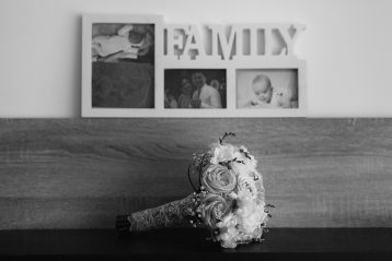 Black and white photo of wedding bouquet in front of a plaque that reads, "Family".
