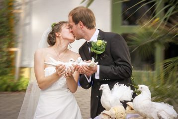 A bride and groom holding doves.