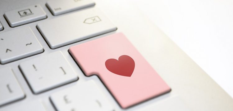 Computer keyboard with a heart on one of the keys.