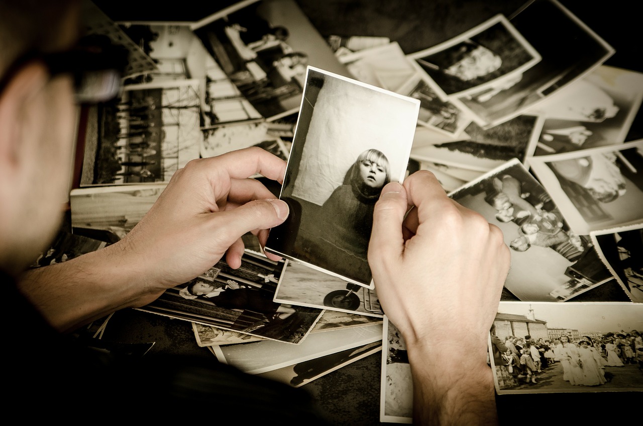 Someone looking through piles of photographs.