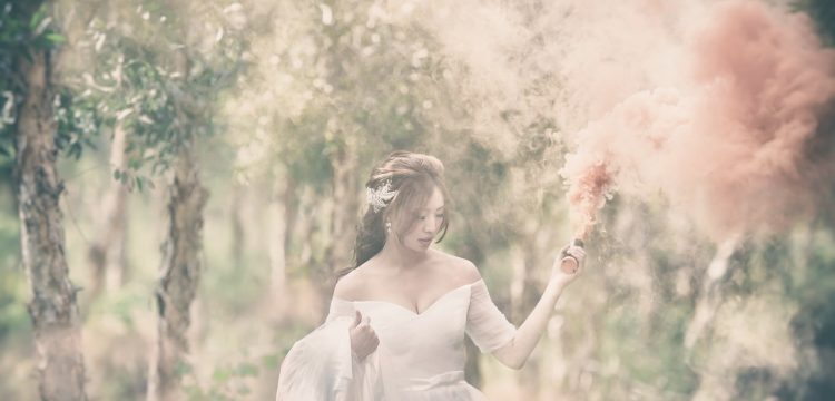 Bride walking through a field or forest.