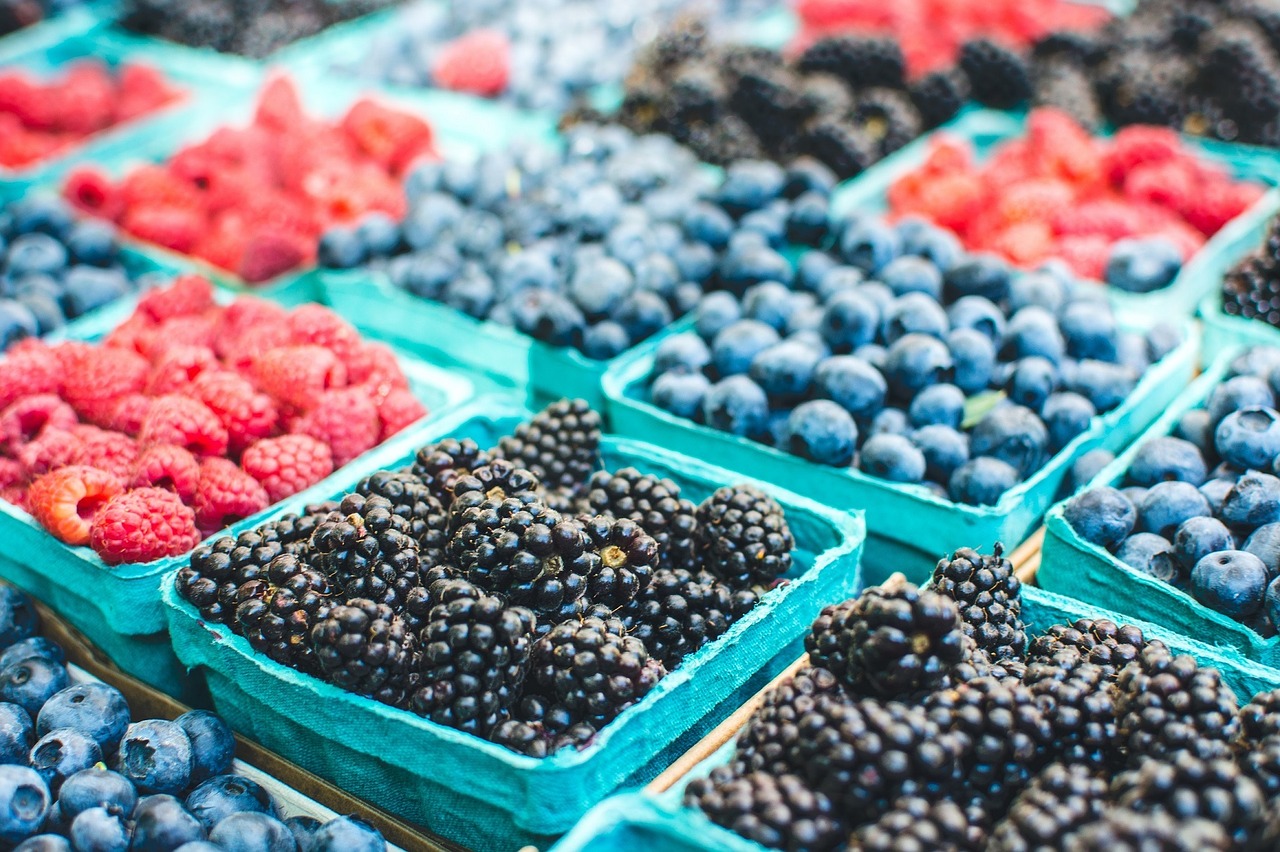 Rows of blueberries and raspberries at a farmers' market.