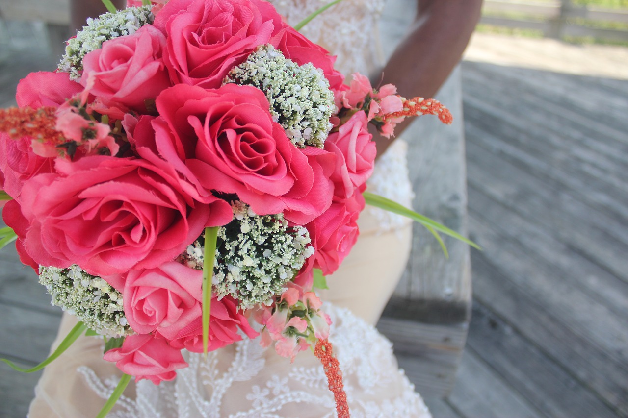 Bride holding a bright pink bouquet of flowers.