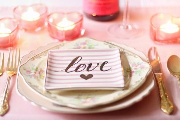 A place setting for a wedding with the word "love" on a plate.