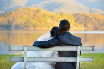 Bride and groom looking at fall foliage.