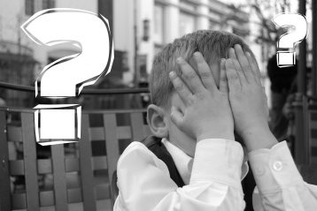 Boy with his hands over his eyes.