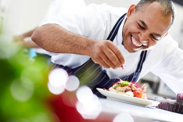 Chef finishing a plate of food.