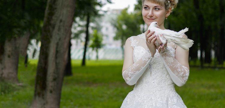 Smiling bride holding a dove.