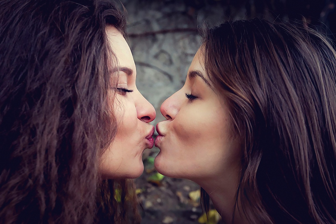 Two women kissing.