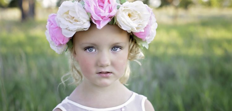 A little girl with big flowers in her hair.