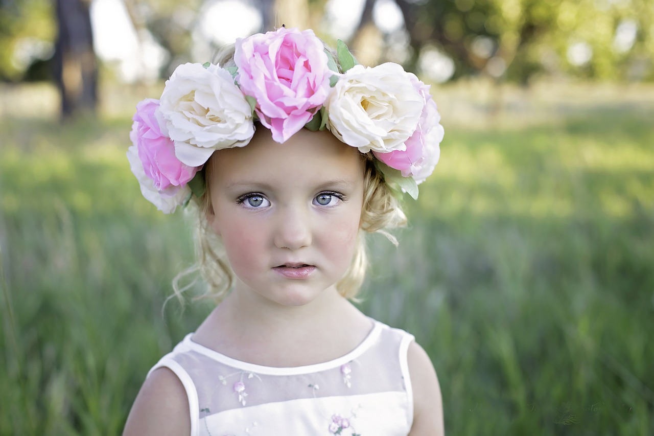 A little girl with big flowers in her hair.