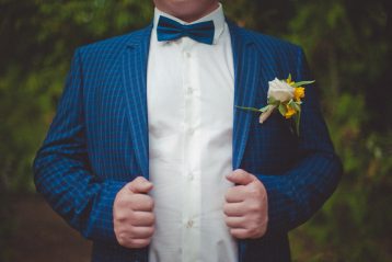 Groom in a blue suit and bow tie.
