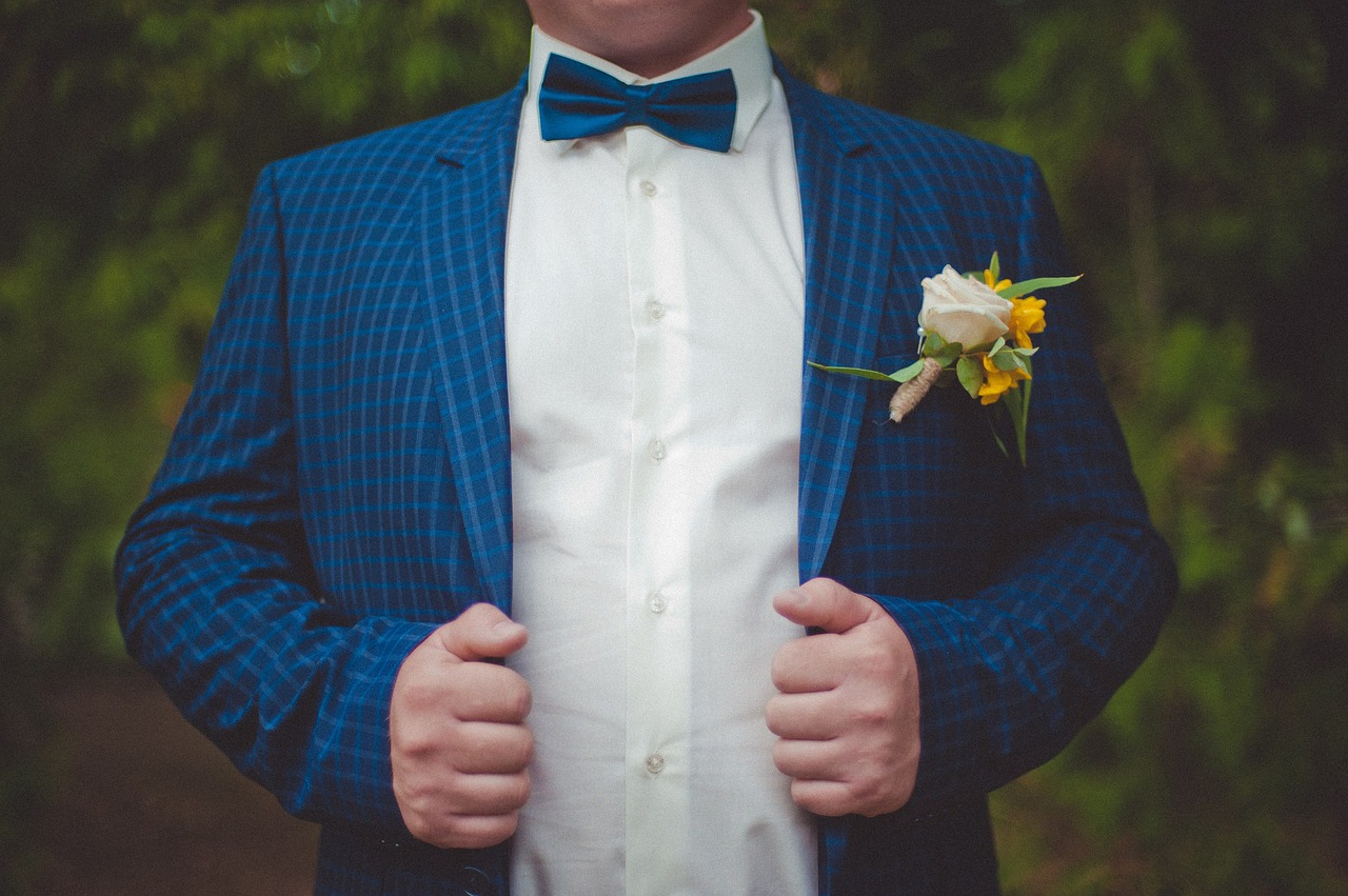 Groom in a blue suit and bow tie.