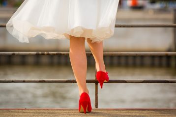 Bride in tea length dress with red heels.