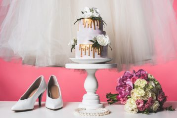 Wedding shoes, a cake, and a bouquet.