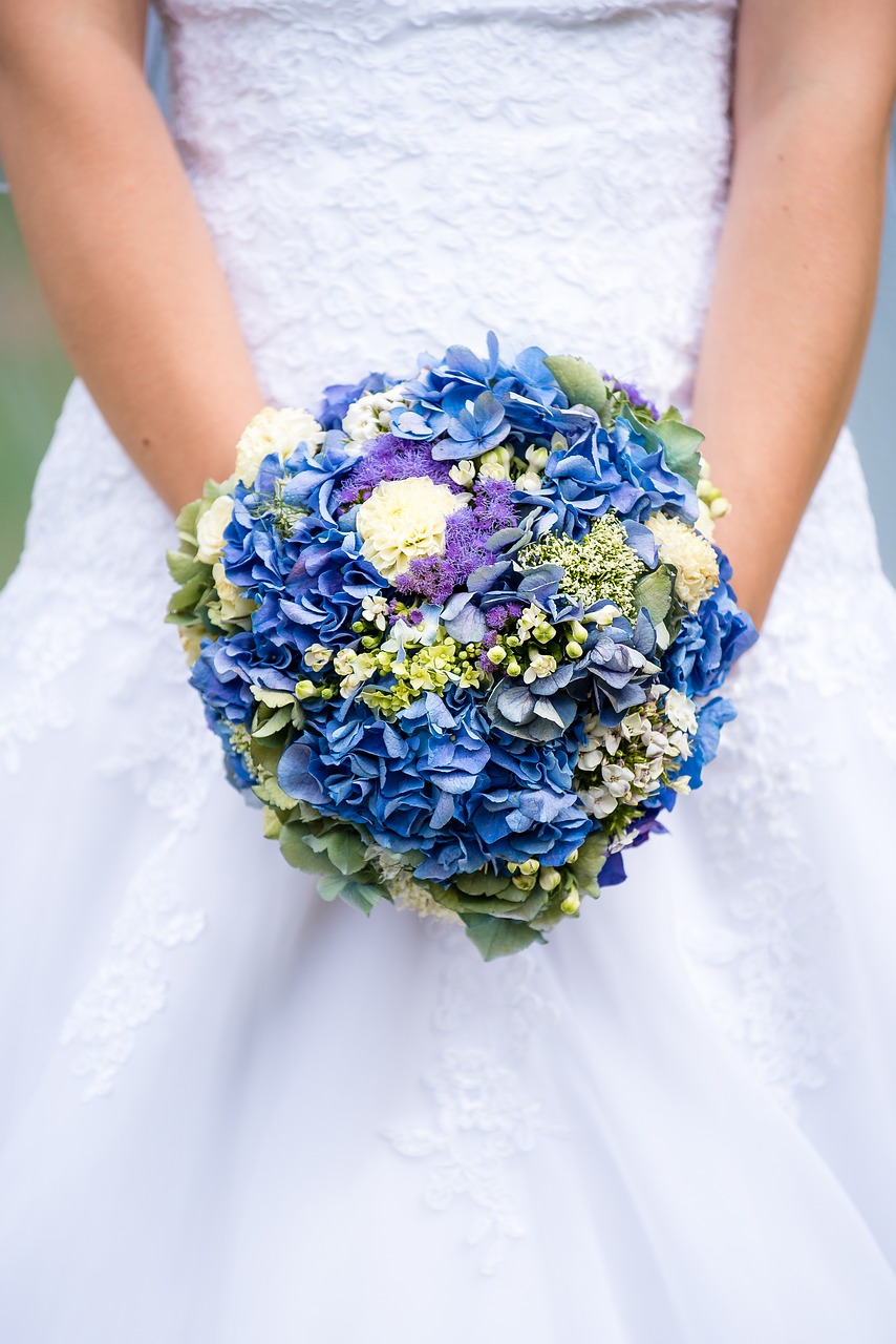 Bride holding blue bouquet.