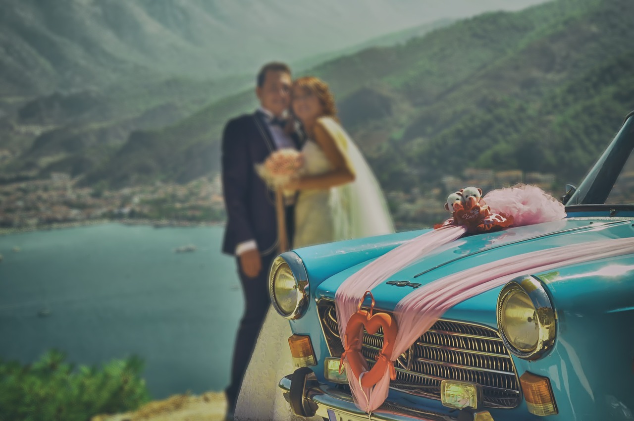 Bride and groom in front of a retro car.