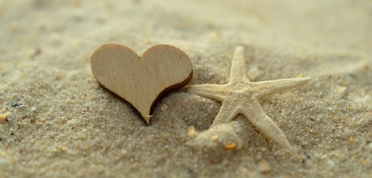 Heart drawn in sand on a beach.