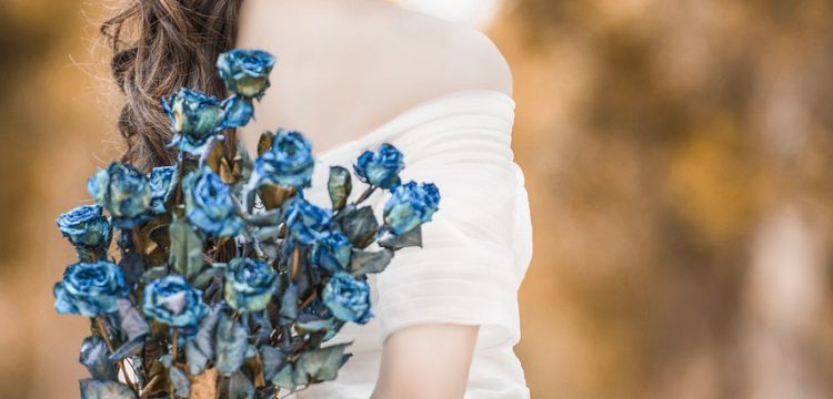 Bride holding a blue bouquet.